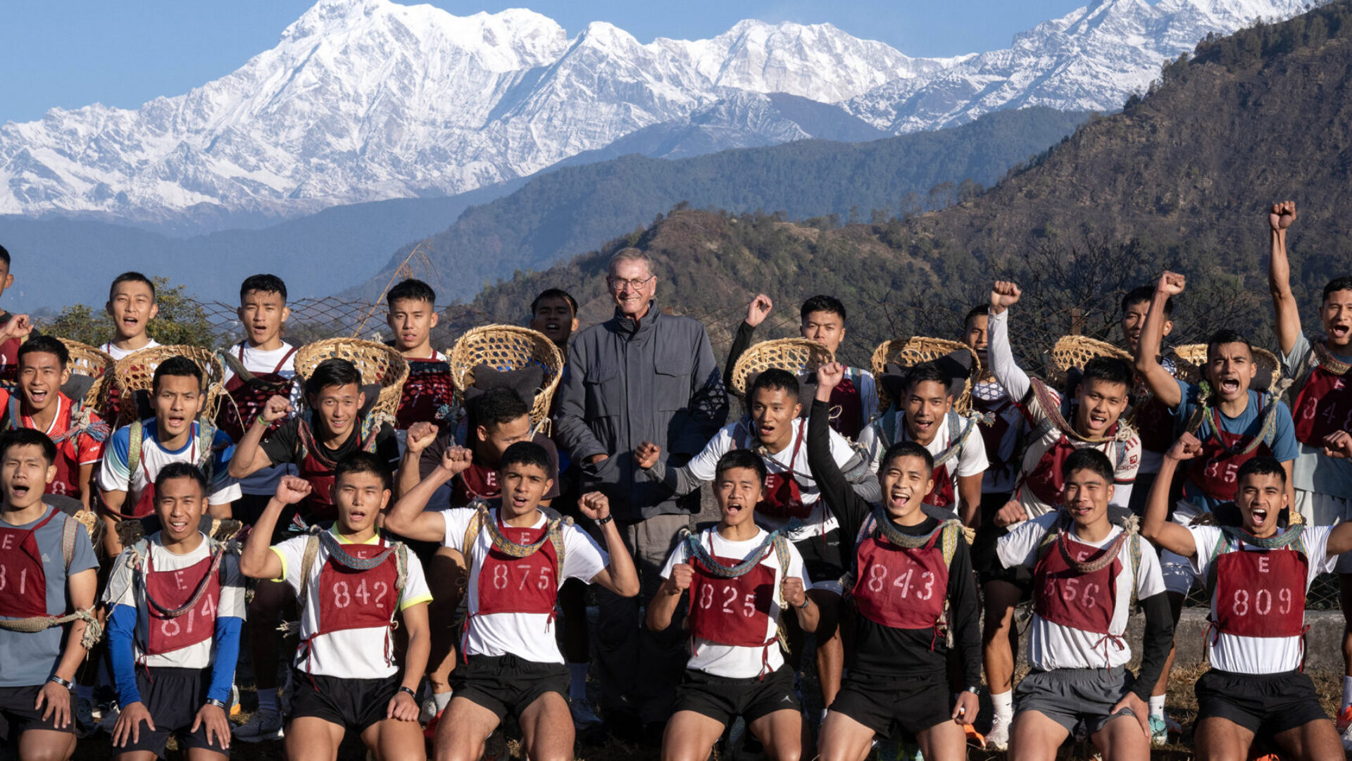 Visit by Lord Ashcroft to the British Gurkha Brigade in Pokhara, Nepal. 2026 Lord Ashcroft with the potential recruits after their doko race. Machhapuchhre, known as Fishtail Mountain, (6,993m) is in Nepal’s Annapurna Range. The doko race is named after the Nepali wicker baskets used for the event and the run plays a key part in the annual recruitment process. The Brigade of Gurkhas is the most oversubscribed unit of the British Army and for its 2026 intake there were more than 10,000 initial application only 323 of whom would be selected. The young men aged 18 to 21have to complete a steep uphill course of 5.8 kilometres – more than 3.4 miles – in the quickest time. To make the challenge even harder, each would-be military recruit must carry on his back the wicker basket containing 15 kilos – more than 33 lbs - of sand. Shoulder straps and a head band are used to support the weight. Each young man knows that if he takes longer than 43 minutes to complete the course, his career dream will be over, at least for that year